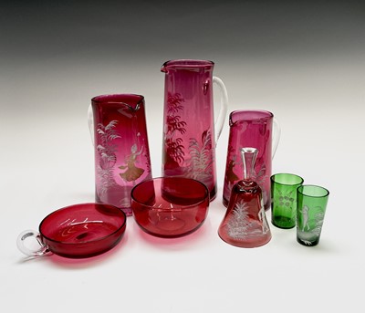 Lot 924 - A set of three graduated cranberry glass jugs,...