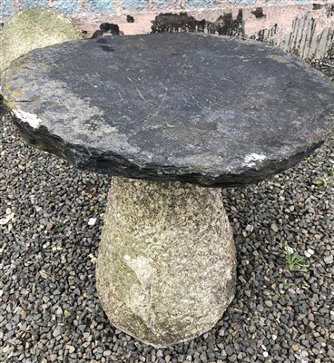 Lot 563 - A tapered granite staddlestone, with later...