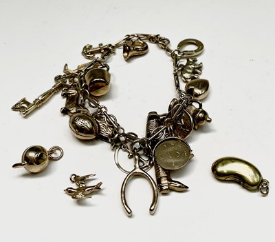 Lot 110 - A 9ct gold charm bracelet with some 19 charms...