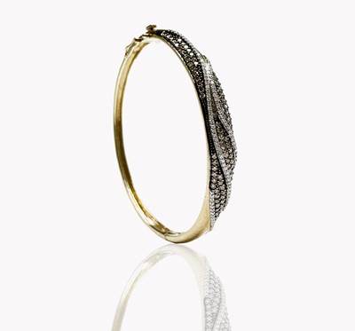 Lot 135 - A contemporary 9ct gold hinged bangle wreathed...
