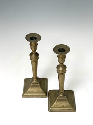 Lot 130 - Two pairs of 18th century brass candlesticks,...