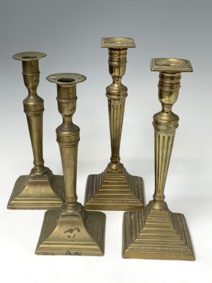 Lot 130 - Two pairs of 18th century brass candlesticks,...