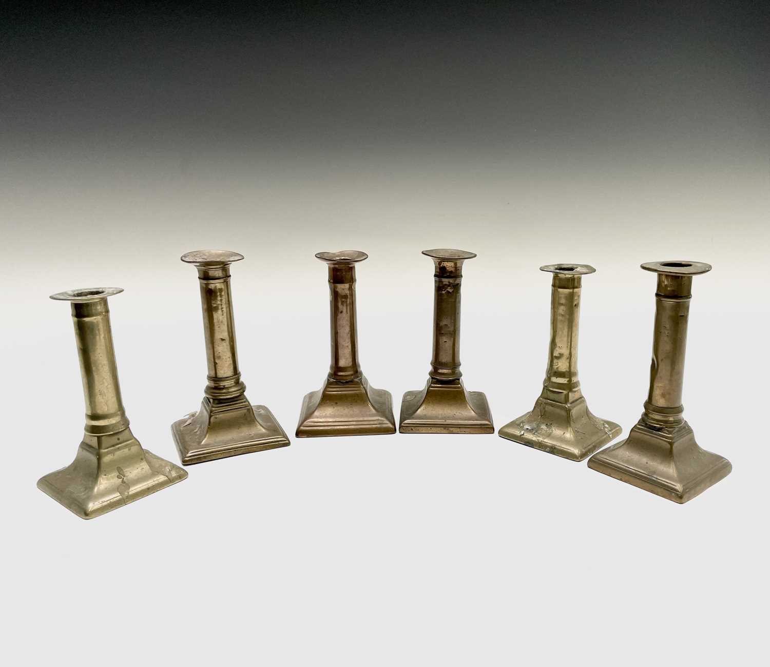 Lot 128 - Three pairs of 18th century brass candlesticks,...
