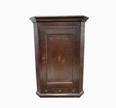 Lot 214 - A George III oak hanging corner cupboard, the...