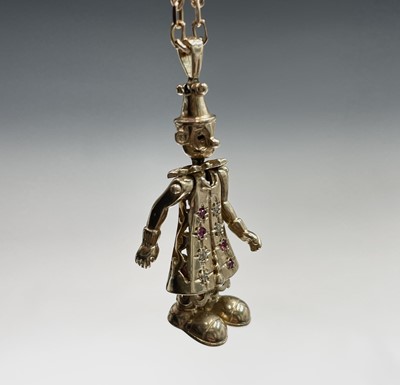 Lot 220 - A gold gem-set articulated clown pendant on...