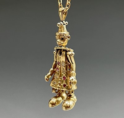 Lot 220 - A gold gem-set articulated clown pendant on...