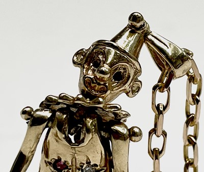 Lot 220 - A gold gem-set articulated clown pendant on...
