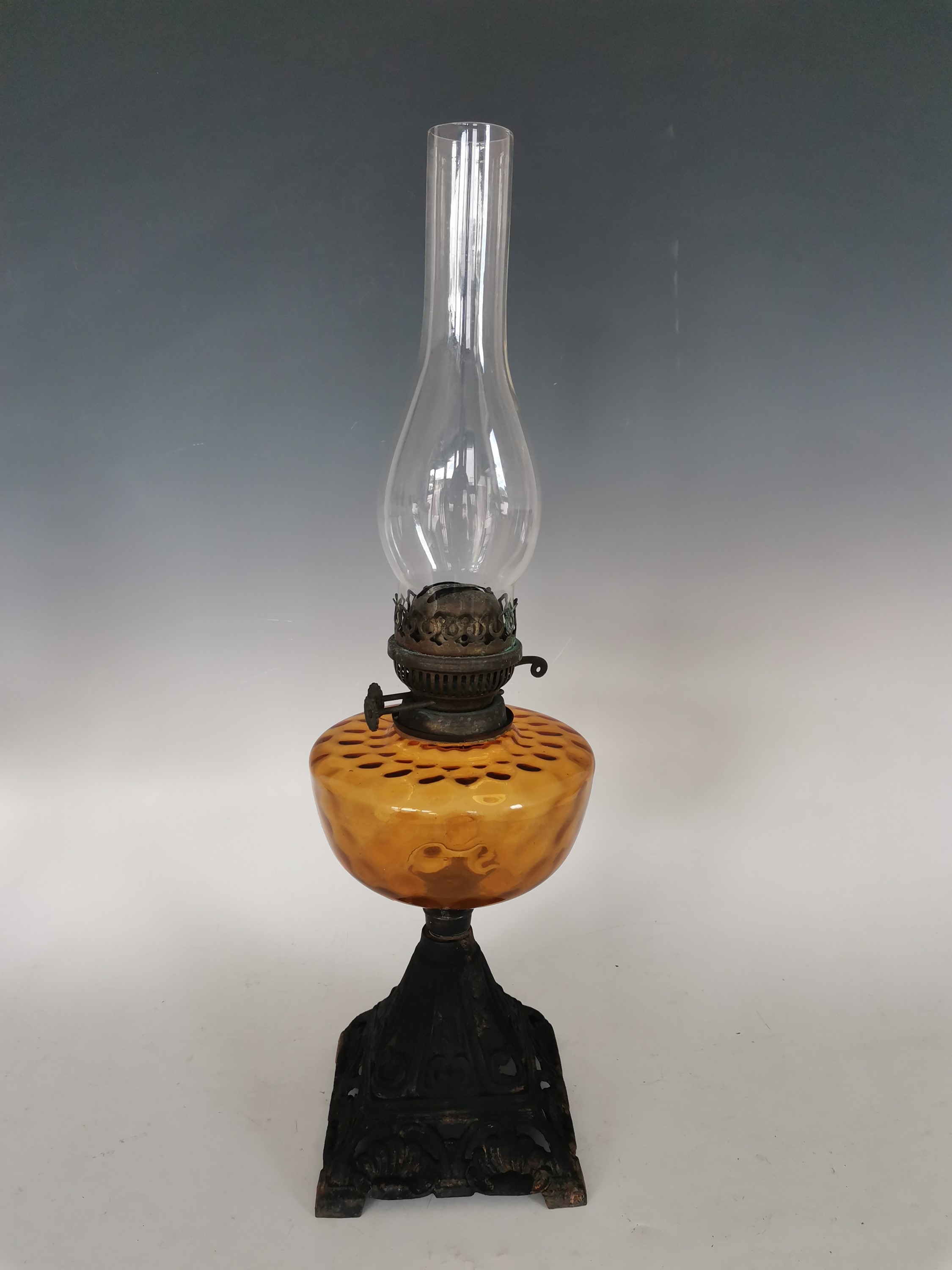 Lot 194 A vintage iron mounted amber glass oil lamp,