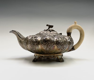 Lot 352 - A George IV ornate melon fluted silver teapot...