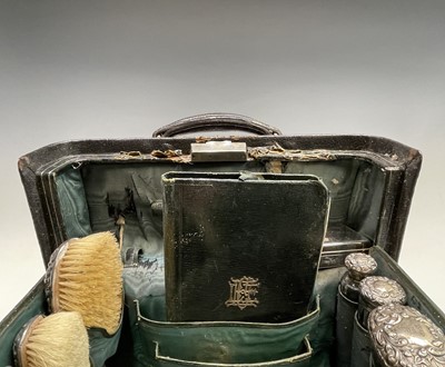 Lot 96 - An Edwardian black leather toilet case with...