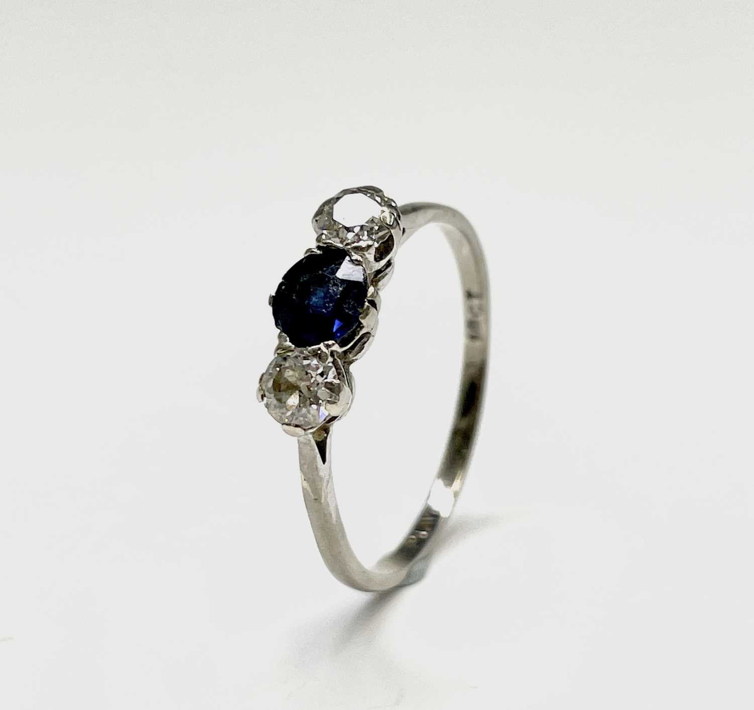 Lot 21 - A three stone platinum ring set with a central...