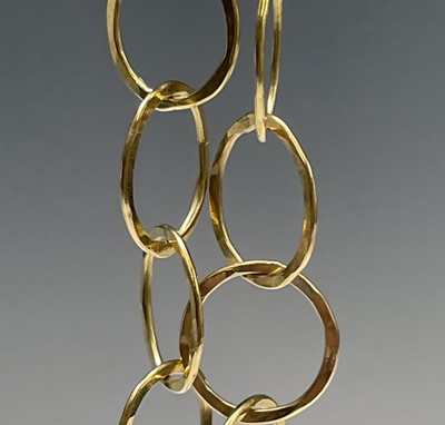 Lot 42 - A contemporary, artist made 18ct gold hammered...