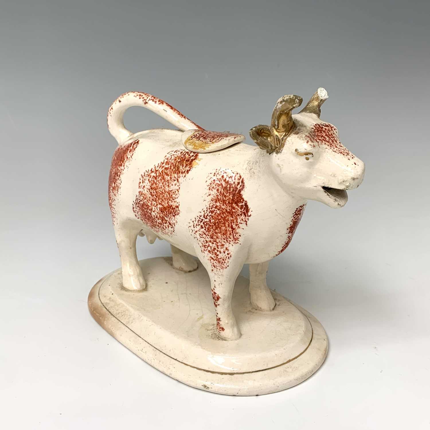 Lot 473 - A 19th century Staffordshire cow creamer,...