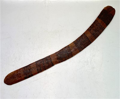 Lot 61 - A wooden boomerang, decorated with horizontal...