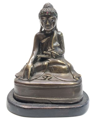 Lot 719 - A Chinese bronze buddha on a wooden stand,...