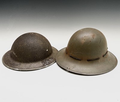 Lot 80 - A WWII steel helmet, painted khaki, the liner...