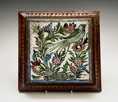 Lot 1053 - A Persian pottery tile, mounted in an oak...