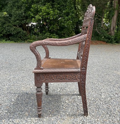 Lot 1001 - An Anglo-Indian carved teak open armchair,...