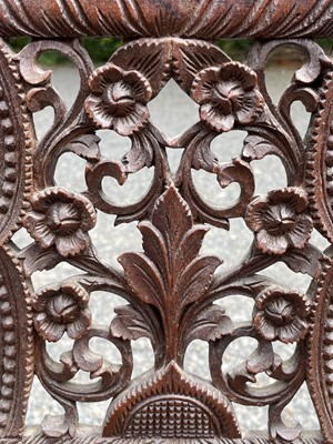 Lot 1001 - An Anglo-Indian carved teak open armchair,...