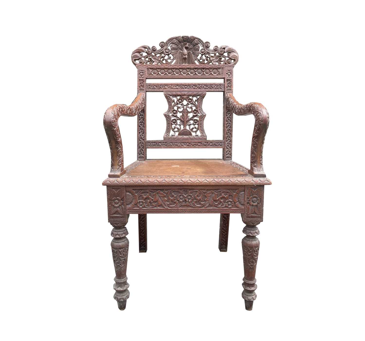 Lot 1001 - An Anglo-Indian carved teak open armchair,...