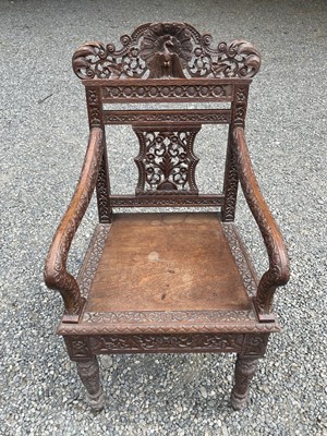 Lot 1001 - An Anglo-Indian carved teak open armchair,...