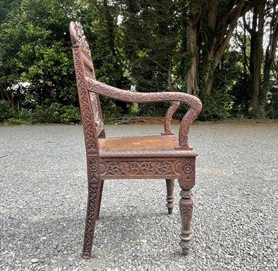 Lot 1001 - An Anglo-Indian carved teak open armchair,...