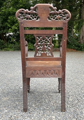 Lot 1001 - An Anglo-Indian carved teak open armchair,...