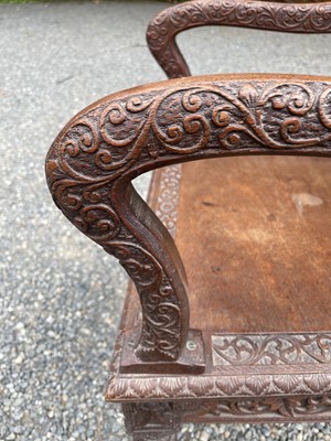 Lot 1001 - An Anglo-Indian carved teak open armchair,...