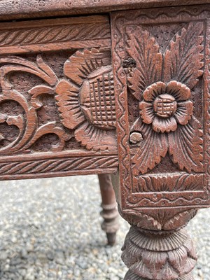 Lot 1001 - An Anglo-Indian carved teak open armchair,...
