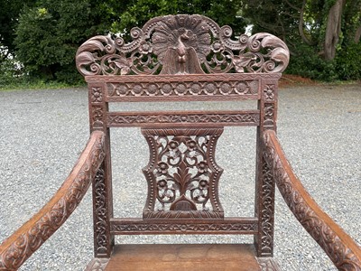 Lot 1001 - An Anglo-Indian carved teak open armchair,...