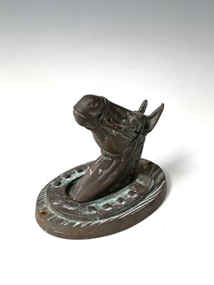 Lot 137 - A bronze horse's mask within a horseshoe...