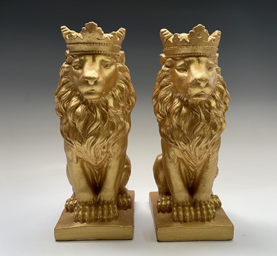 Lot 268 - A pair of gold painted seated lions wearing...