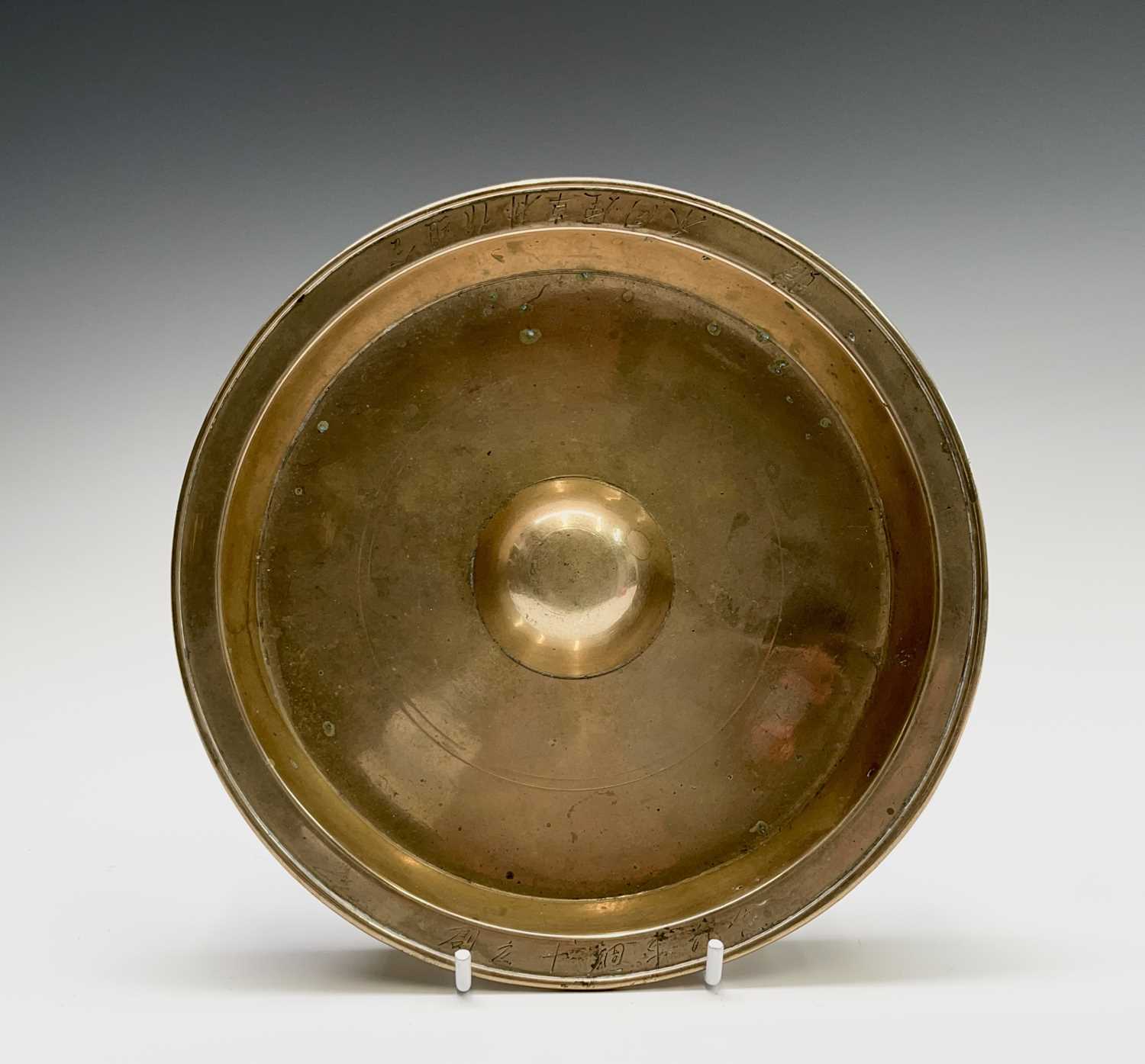 Lot 255 - A Chinese polished bronze dish, the rim with...