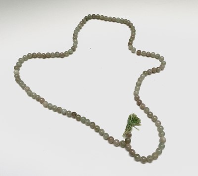 Lot 319 - A string of jade beads, of varied colour, two...