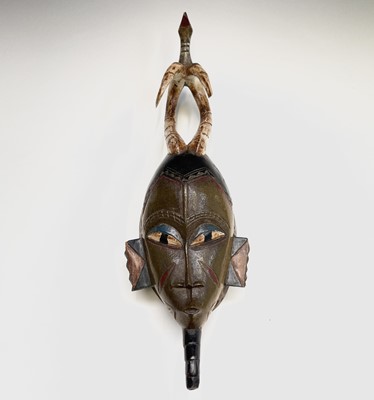 Lot 297 - An African carved tribal mask, the horned...