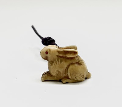 Lot 409 - A Japanese ivory netsuke in the form of a hare,...
