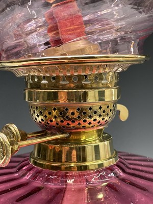 Lot 300 - A Victorian cranberry glass and brass oil lamp,...