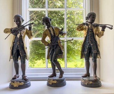 Lot 347 - A group of three bronze figures of Mozart,...