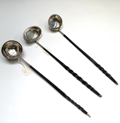 Lot 73 - Three silver punch ladles with unadorned bowls...