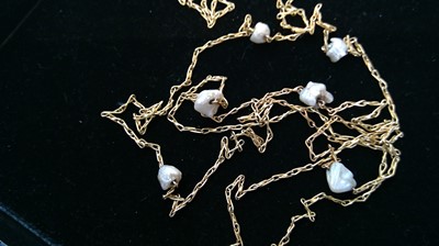 A 9ct gold long chain with seven baroque...