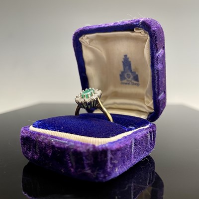 An 18ct yellow gold oval diamond and emerald...