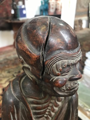 Lot 114 - A Chinese carved rootwood figure of a man in a...