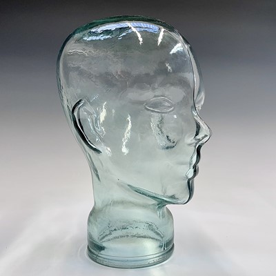 Lot 146 - A moulded glass shop display head. Height 25cm.