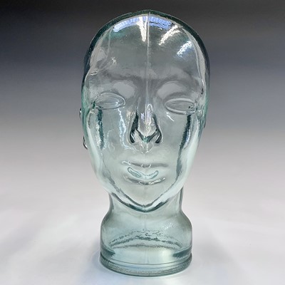 Lot 146 - A moulded glass shop display head. Height 25cm.