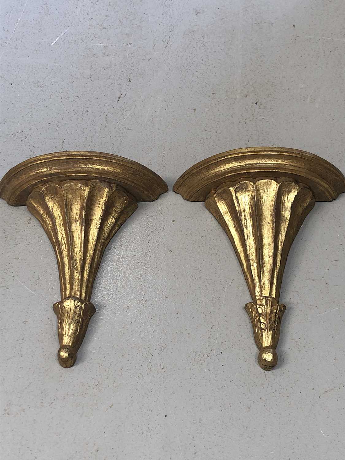 Lot 24 - A pair of giltwood fluted wall brackets,...