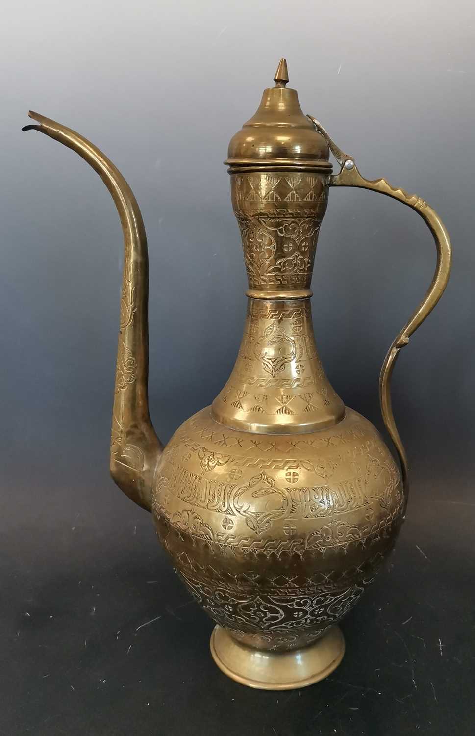 Lot 20 - An ornate Middle Eastern brass ewer with...