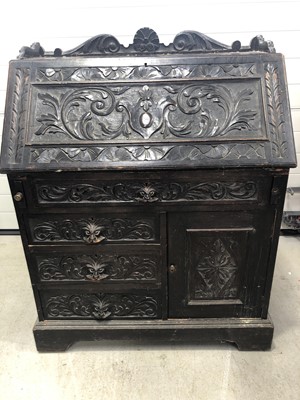 Lot 35 - An oak ornate carved bureau with one long and...