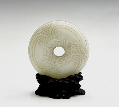 Lot 187 - A Chinese carved jade bi-disc, Qing Dynasty,...