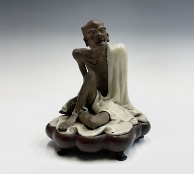 Lot 218 - A Chinese Jun-type figure of a seated luohan,...