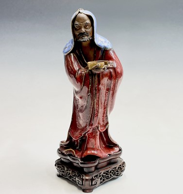 Lot 221 - A Chinese Shiwan pottery figure of a bearded...